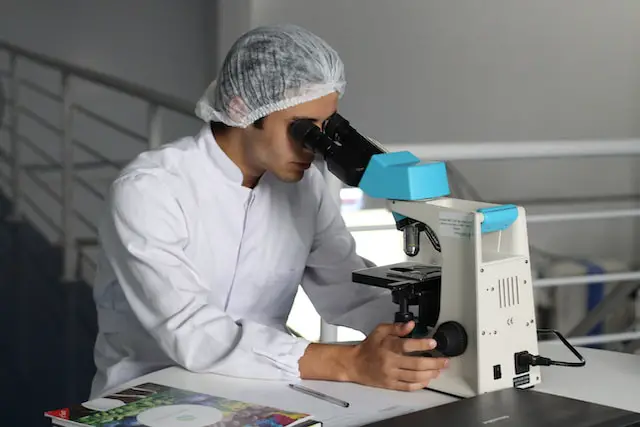 Picture of a person looking into a microscope 