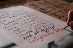 Picture of person writing with different styles of calligraphy 