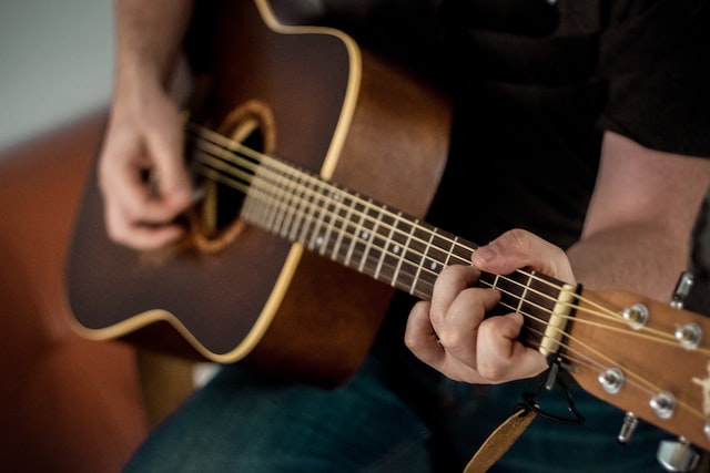 Picture of a person playing an acoustic guitar