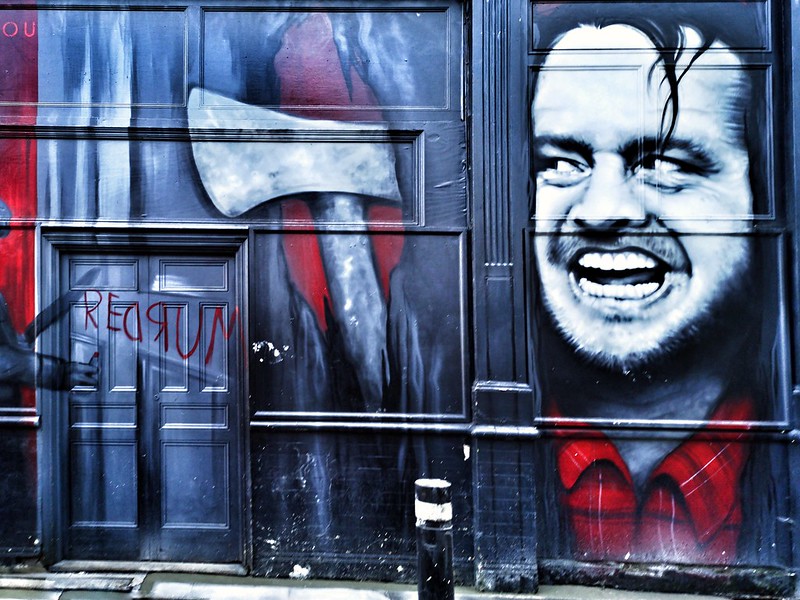 Picture of a wall painted by a scary picture of psychopathic man