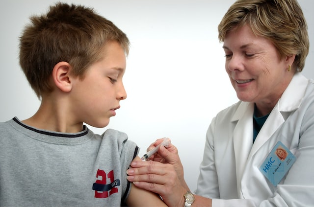 picture of a nurse administering an intravenous injection to a young boy