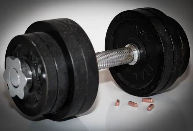 Picture of a dumbell with what appears to be steroids lying next to it 