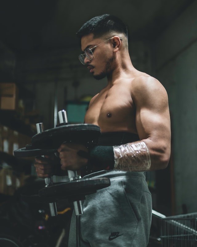 Picture of a man holding two dumbbells close to his chest