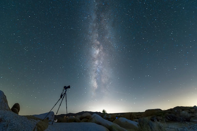 Picture of a telescope in the backdrop of a night sky filled with stars