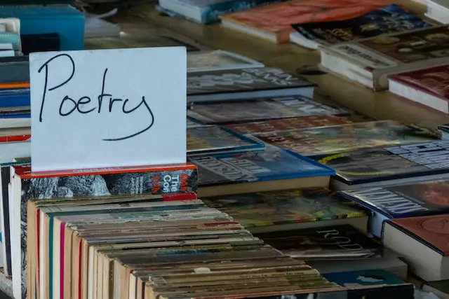 Picture of a lots of books with a sign "poetry" over some of them