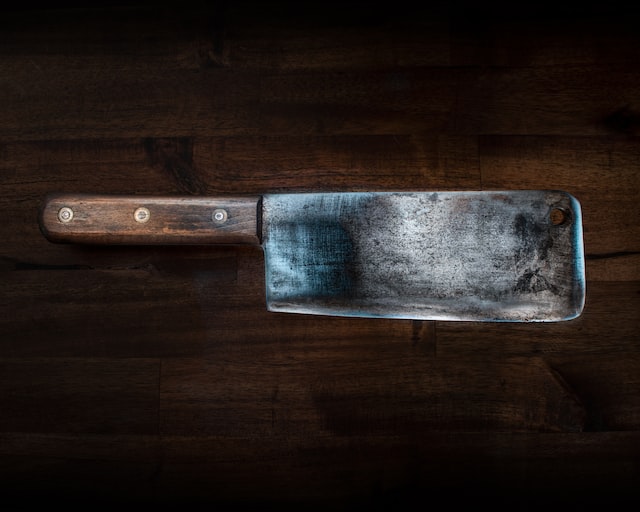 Picture of a cleaver with a brown wooden handle 