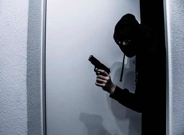 picture of a man breaking in with a weapon 
