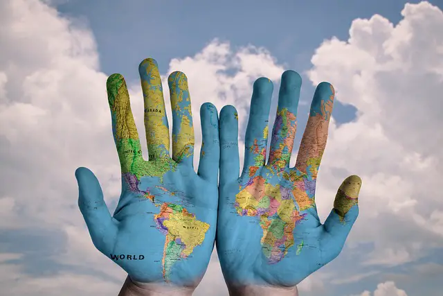 Picture of the world map painted on the palms of a person - depicting globalization