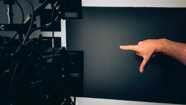 Picture of a man pointing at a video camera 