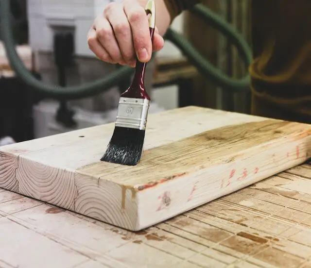Picture of a person applying varnish on a piece of wood
