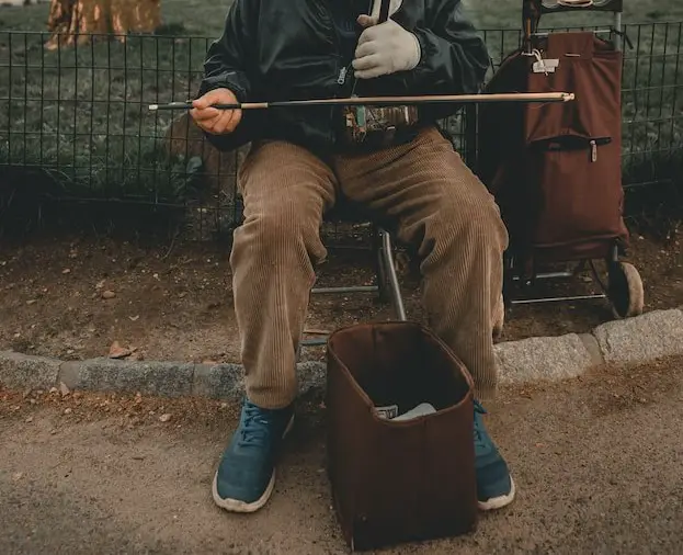 Picture of a man playing a musical instrument on the roadside
