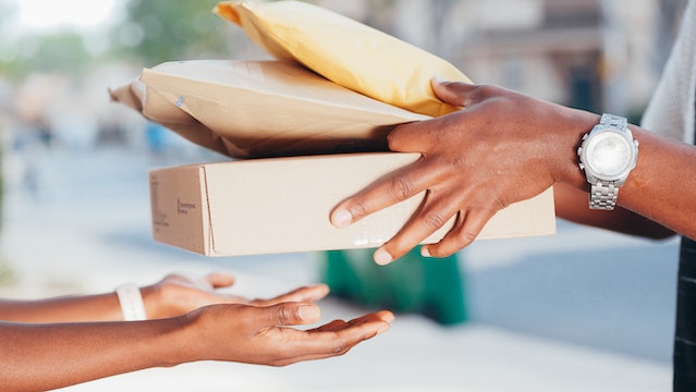 Picture of a person handing over some packages to another person