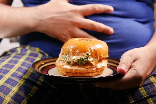 Picture of an overweight person with a burger 