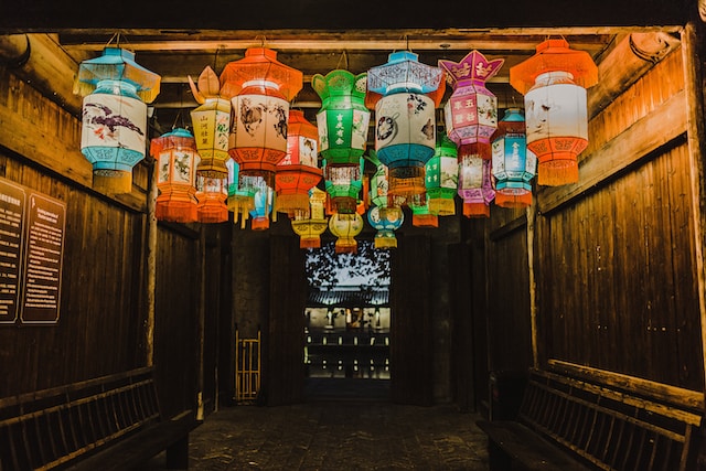 Picture of some colorful lanterns hanging on a roof 