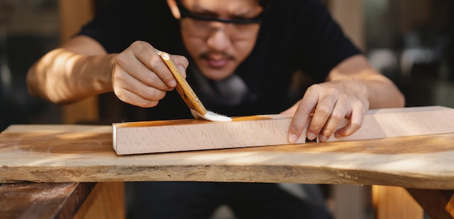 picture of a person applying varnish to a piece of wood
