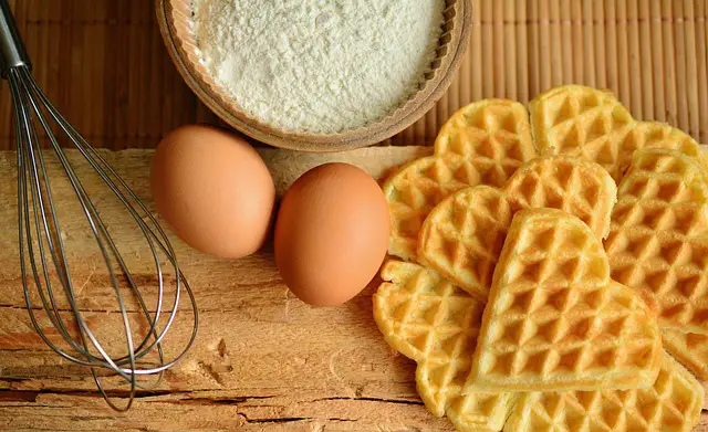 picture of some waffles with some ingredients and equipment used to make them
