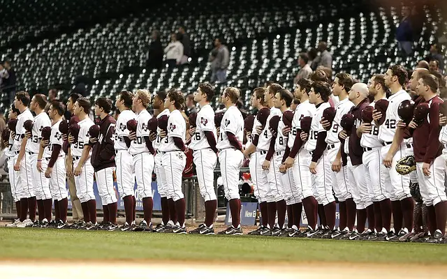 picture of baseball players singing the notional anthem before a game