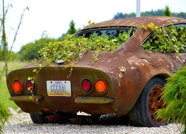 A picture of a car slowly corroding due to chemical reactions